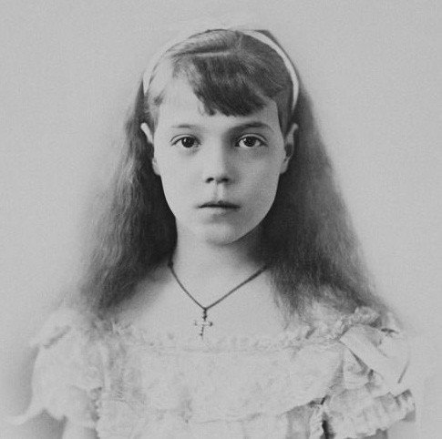 Black-and-white photograph of a girl in a white dress and headband
