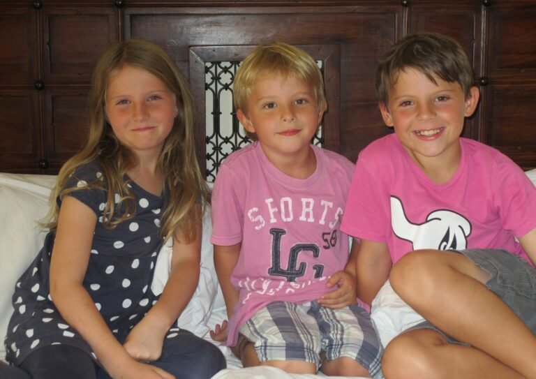 Photograph of three children sitting close together