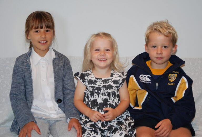 Photograph of three young children seated side by side
