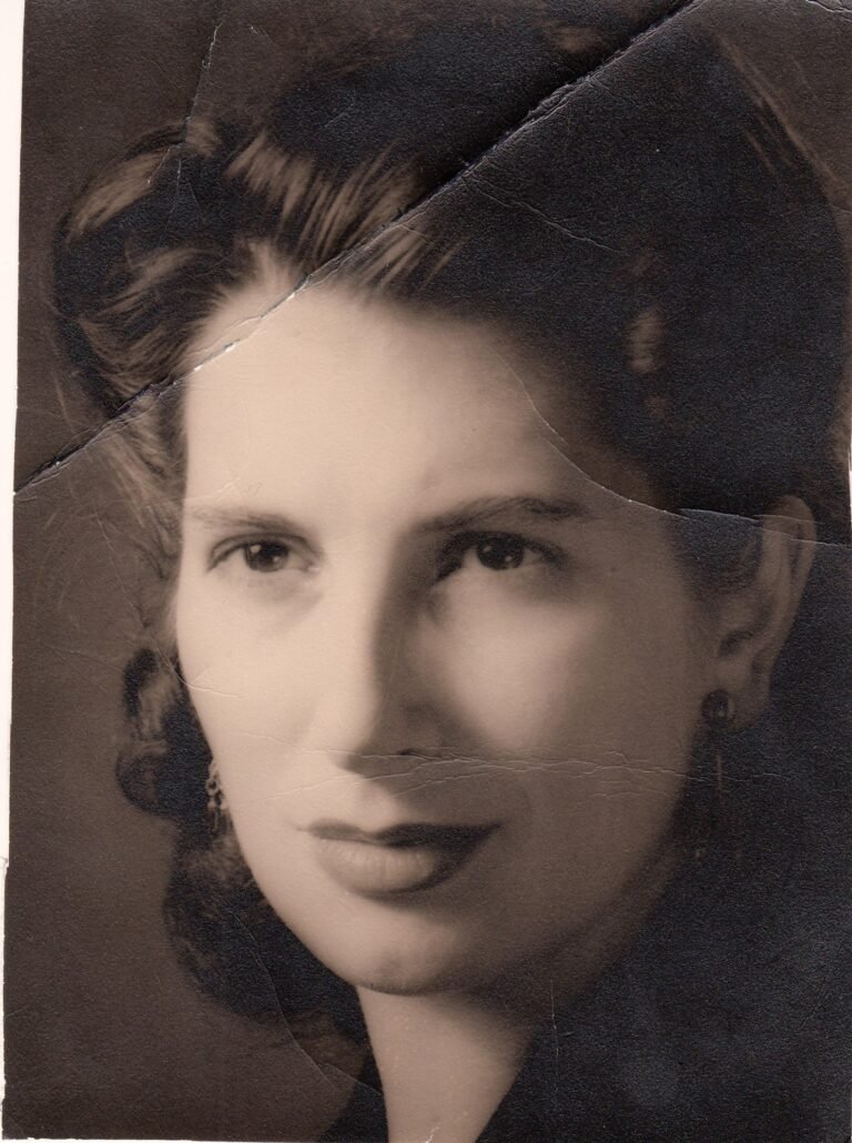 Aged and creased photograph of a woman with waved hair