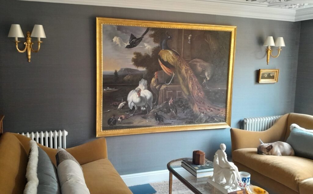 A framed Hondecoeter reproduction above a sofa in a traditional sitting room