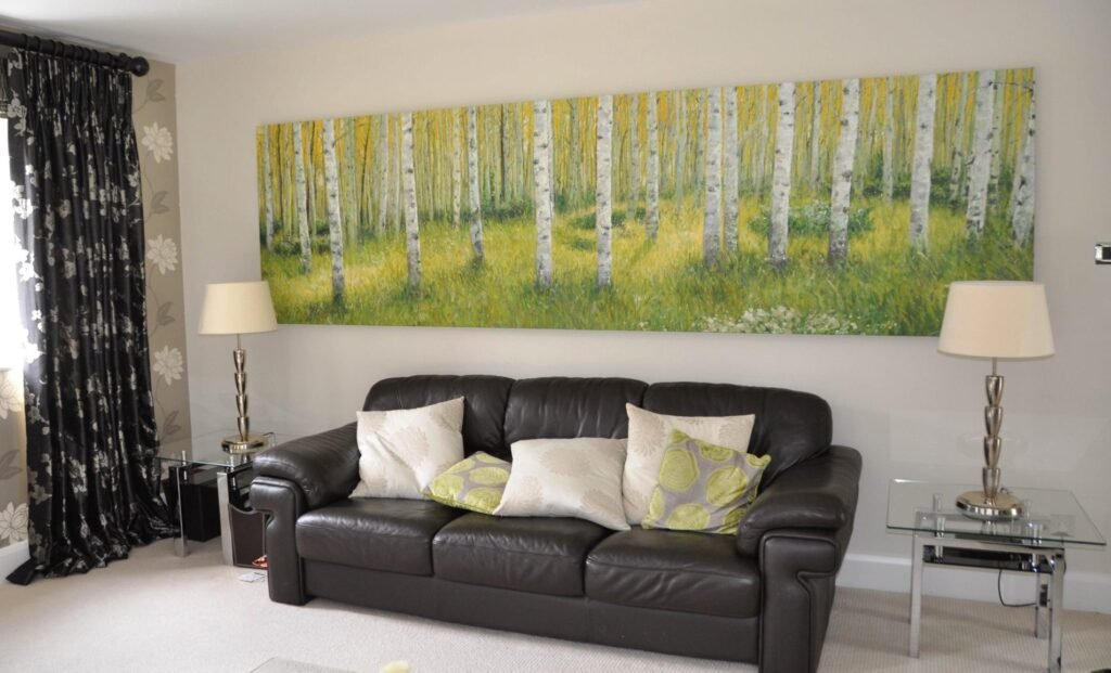 A large birch woodland landscape above a leather sofa in a living room