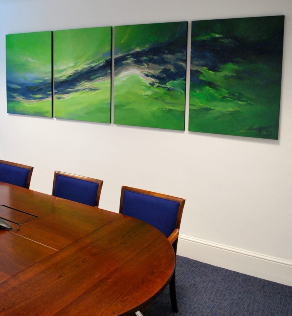 A four-panel green abstract painting above a meeting-room table